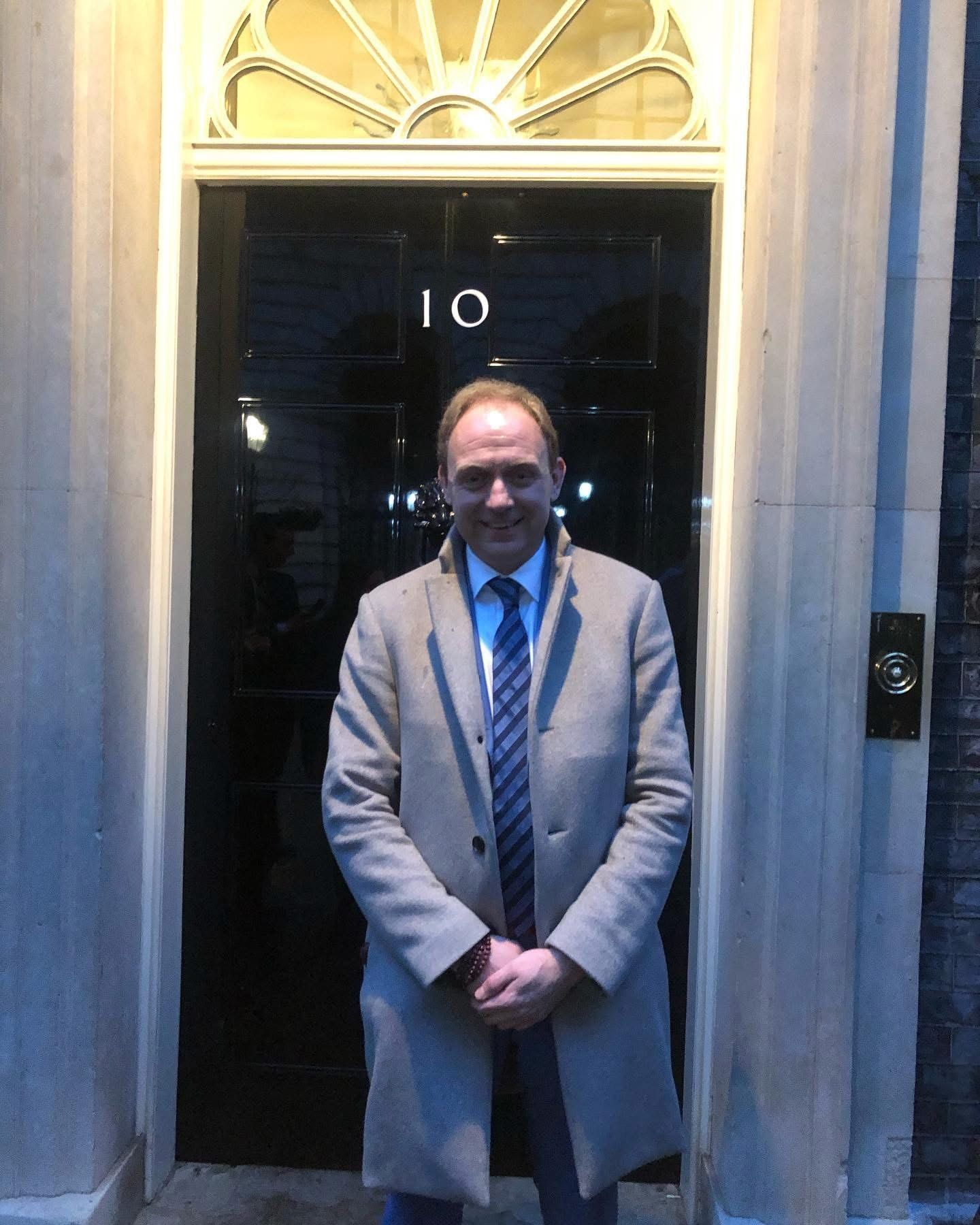Daniel Fitzhenry outside the door of 10 Downing Street in the evening, March 2023