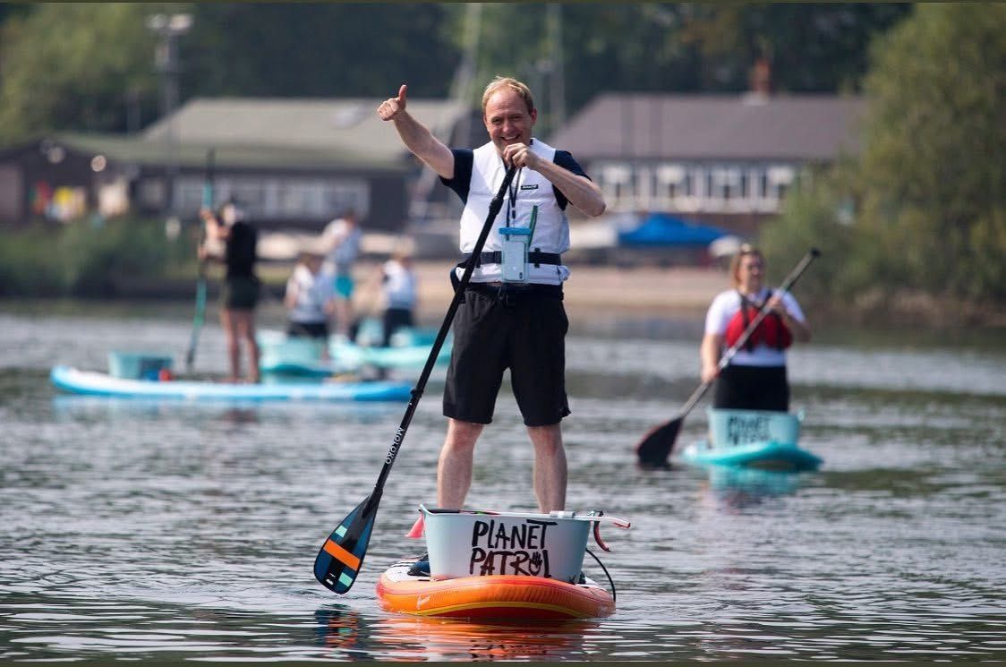 Daniel Fitzhenry giving a thumbs up on a paddleboard during a Planet Patrol river clean-up, Southampton