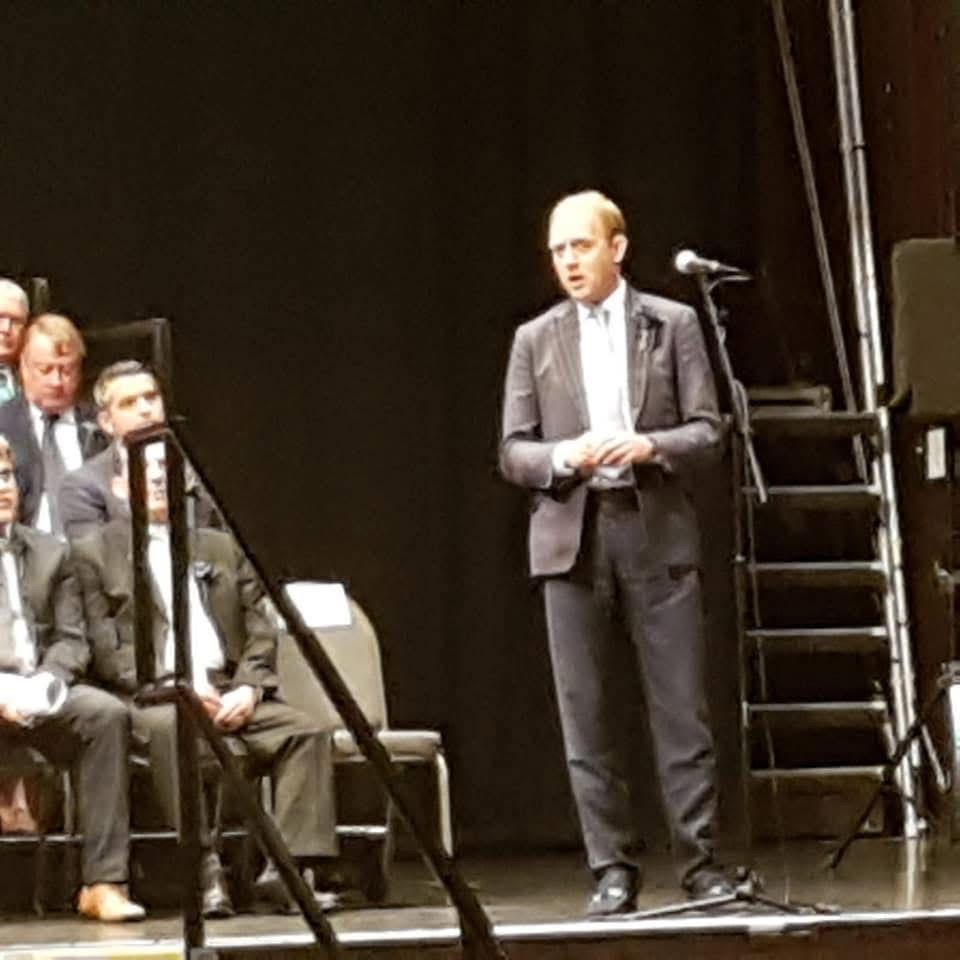 Daniel Fitzhenry speaking on stage as Leader of the Opposition at Southampton's Mayor Making ceremony in 2019, with councillors seated behind him